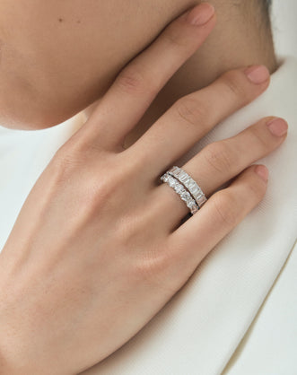 Close-up model wears Soho 0.20ct emerald cut half eternity band in 18ct white gold