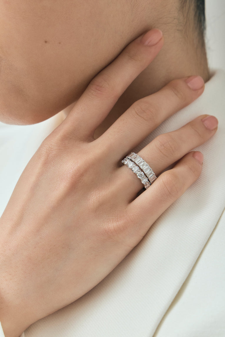 Close-up model wears Soho 0.20ct emerald cut half eternity band in 18ct white gold