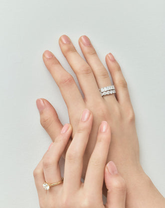 Close-up model wears Soho 0.20ct emerald cut half eternity band in platinum