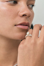Model wears Nassau oval cut diamond band engagement ring in 18ct yellow gold
