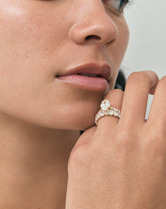 Close-up model wears Cler 0.20ct oval half eternity band in 18ct yellow gold