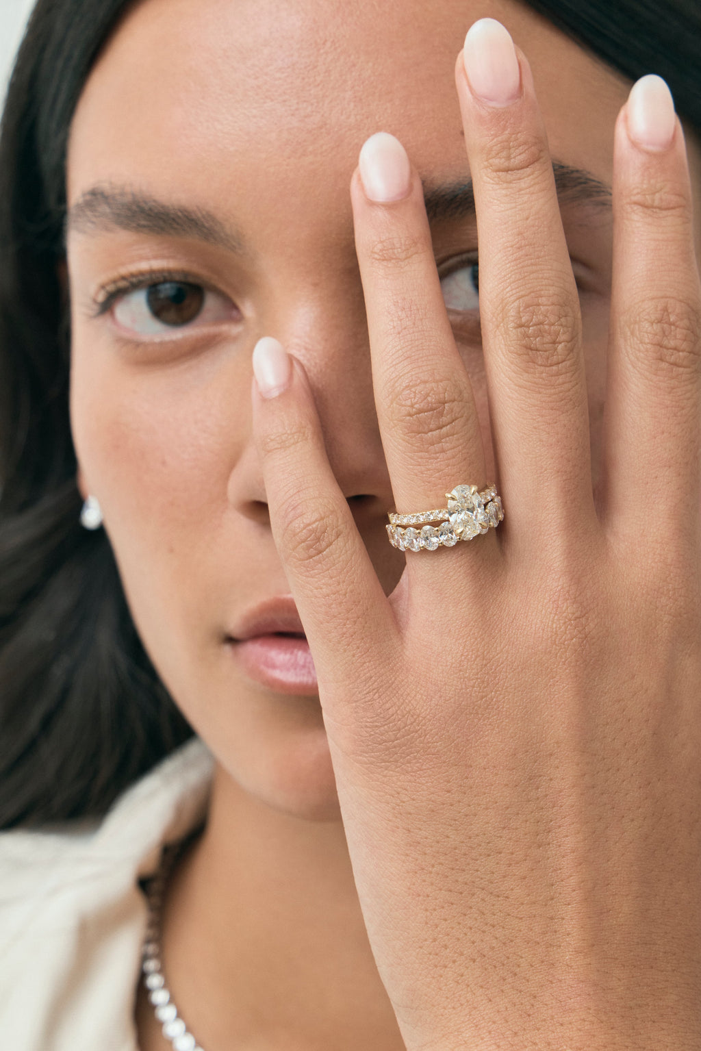 Model wears Nassau oval cut diamond band engagement ring in 18ct yellow gold