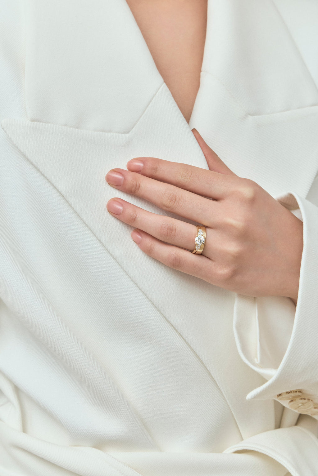 Model wear Cornelia round brilliant pear side stone engagement ring with diamond band in 18ct yellow gold