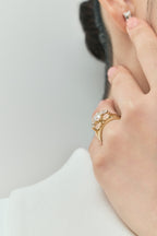 Model wears Cornelia round brilliant pear side stone engagement ring with lab-grown diamond band in 18ct yellow gold