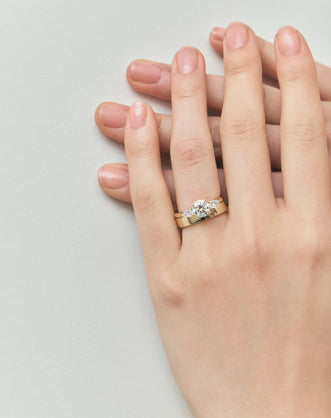Close-up Cornelia round brilliant pear side stone engagement ring with lab-grown diamond band in 18ct yellow gold