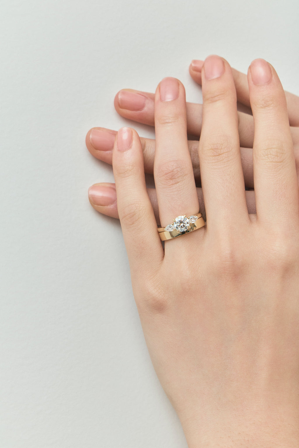 Close-up Cornelia round brilliant pear side stone engagement ring with lab-grown diamond band in 18ct yellow gold