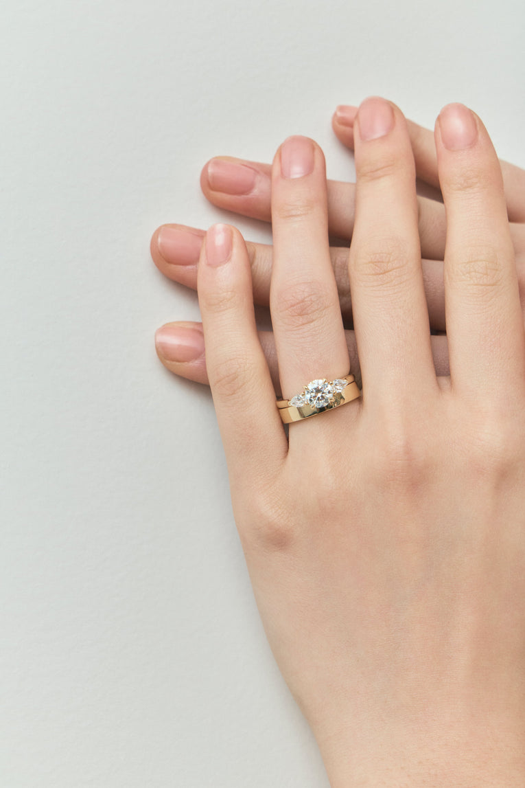 Close-up Cornelia round brilliant pear side stone engagement ring with lab-grown diamond band in 18ct yellow gold