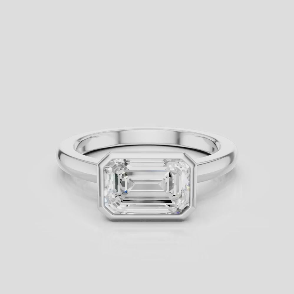 Rowan emerald cut solitaire bezel East-West engagement ring in platinum
