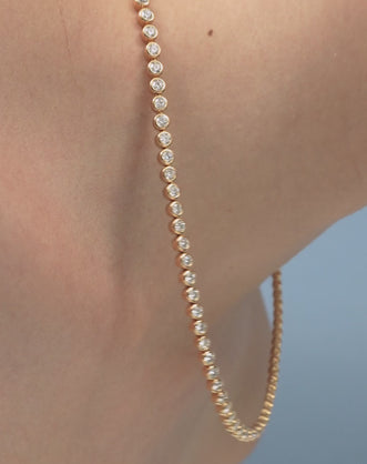 Model wearing York bezel set tennis necklace in 18ct yellow gold