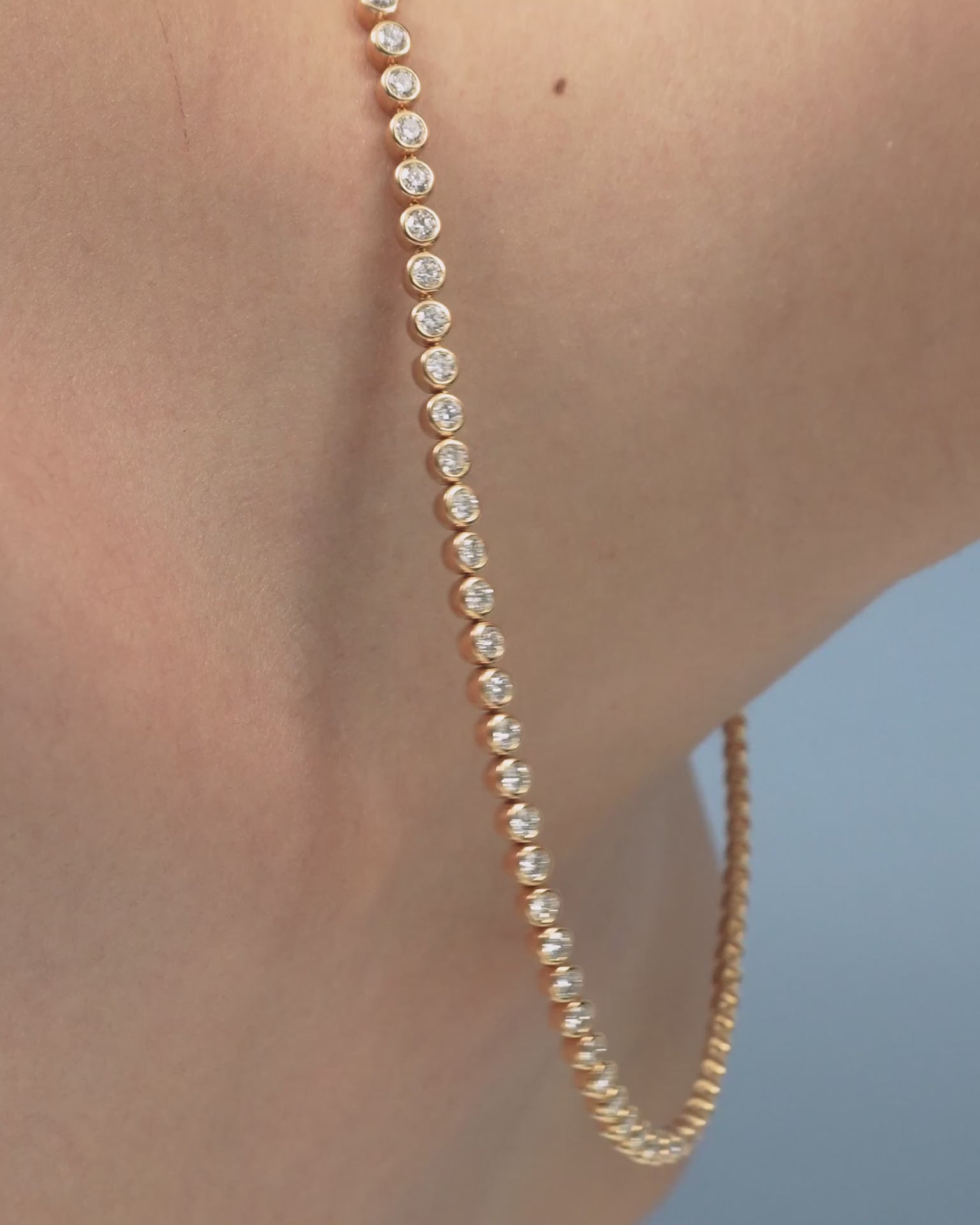 Model wearing York bezel set tennis necklace in 18ct yellow gold