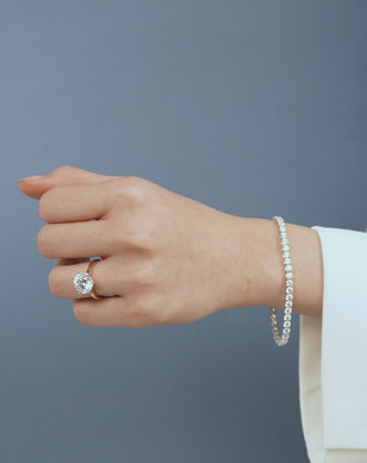 Model wears Cambon round brilliant six claw solitaire swept shoulder engagement ring in 18ct yellow gold