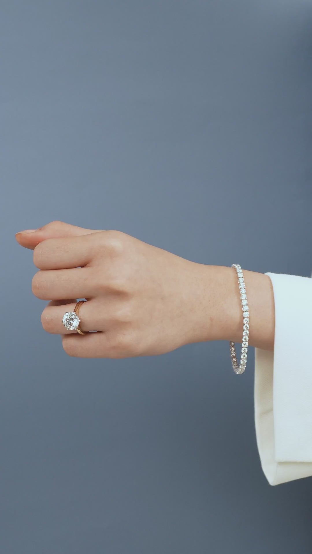 Model wears Cambon round brilliant six claw solitaire swept shoulder engagement ring in 18ct yellow gold