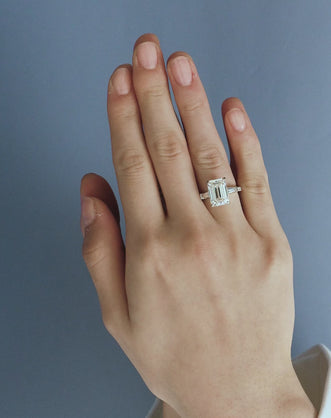 Model wears Elizabeth 5ct emerald cut tapered baguette engagement ring in 18ct white gold