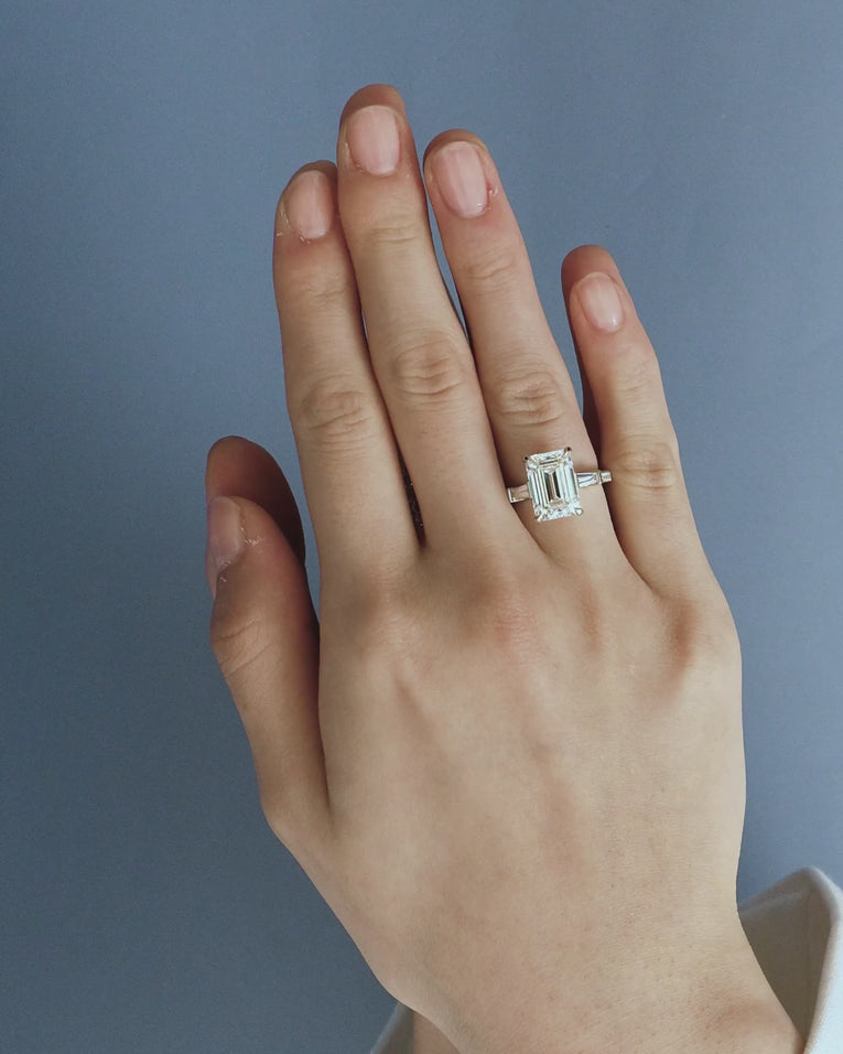 Model wears Elizabeth 5ct emerald cut tapered baguette engagement ring in 18ct white gold