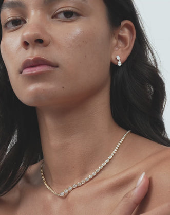 Model wears Madame 0.50ct emerald pear cut drop earrings in 18ct white gold