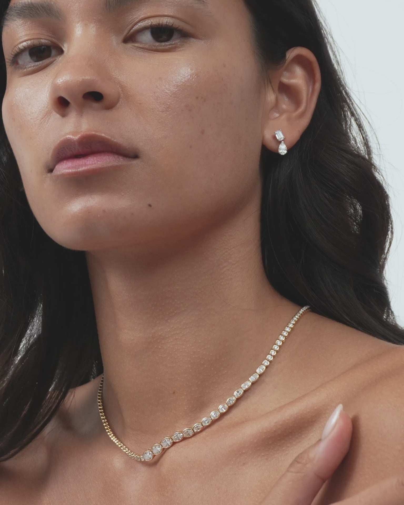 Model wears Madame 0.50ct emerald pear cut drop earrings in 18ct white gold