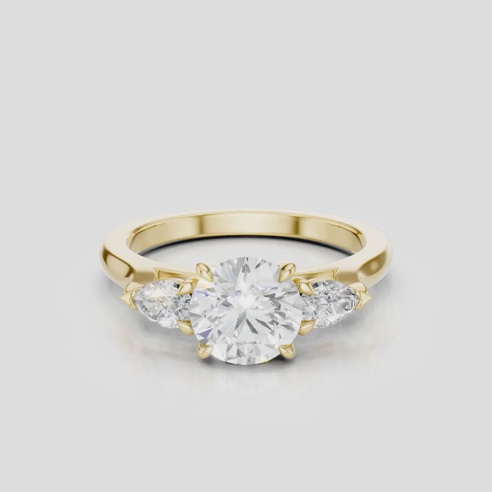 Cornelia round brilliant pear side stone engagement ring with diamond band in 18ct yellow gold