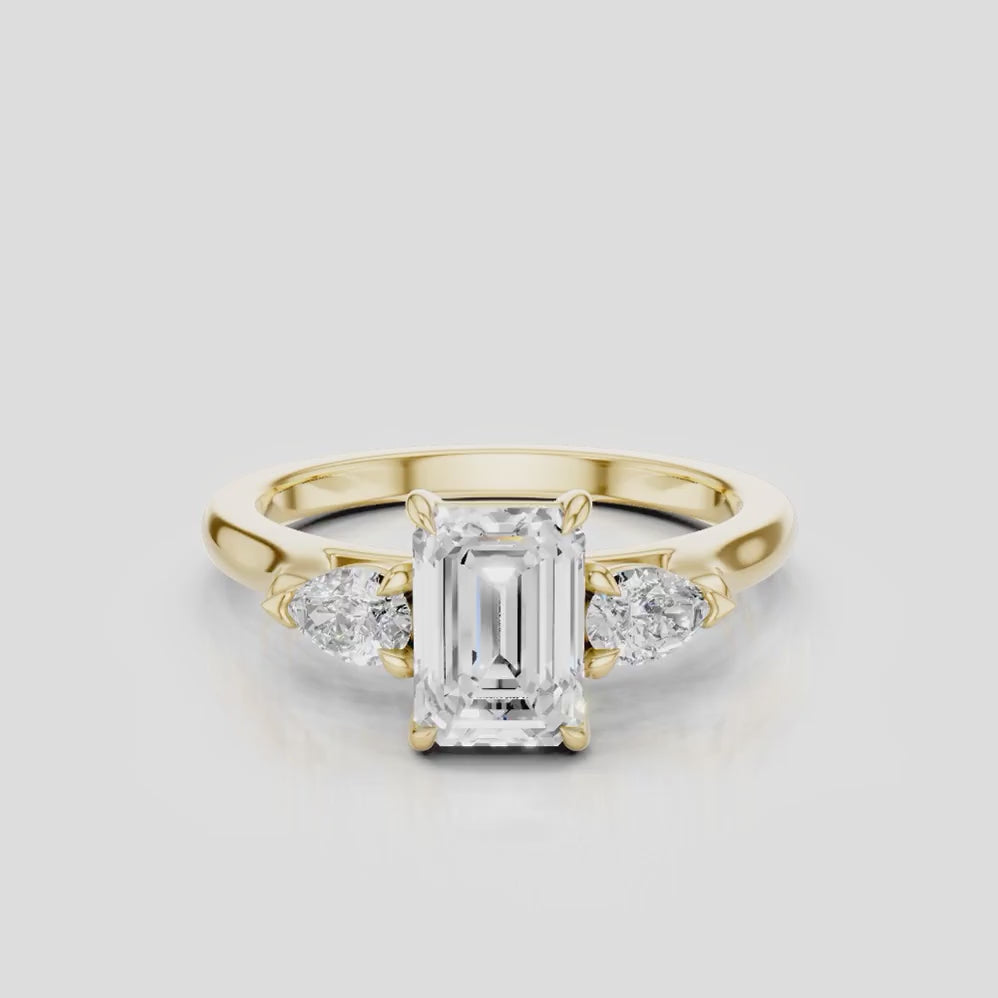 Bruton emerald cut pear side stone engagement ring in 18ct yellow gold