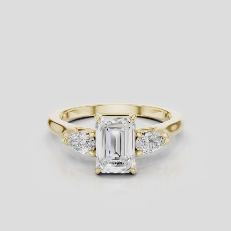 Bruton emerald cut pear side stone engagement ring in 18ct yellow gold