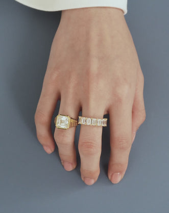 Model wears Rivington 5ct asscher signet bezel grooved band engagement ring in 18ct yellow gold
