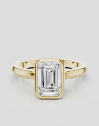 Sutton emerald cut solitaire bezel north-south engagement ring in 18ct yellow gold