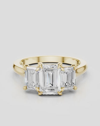 Marion emerald cut trilogy engagement ring in 18ct yellow gold