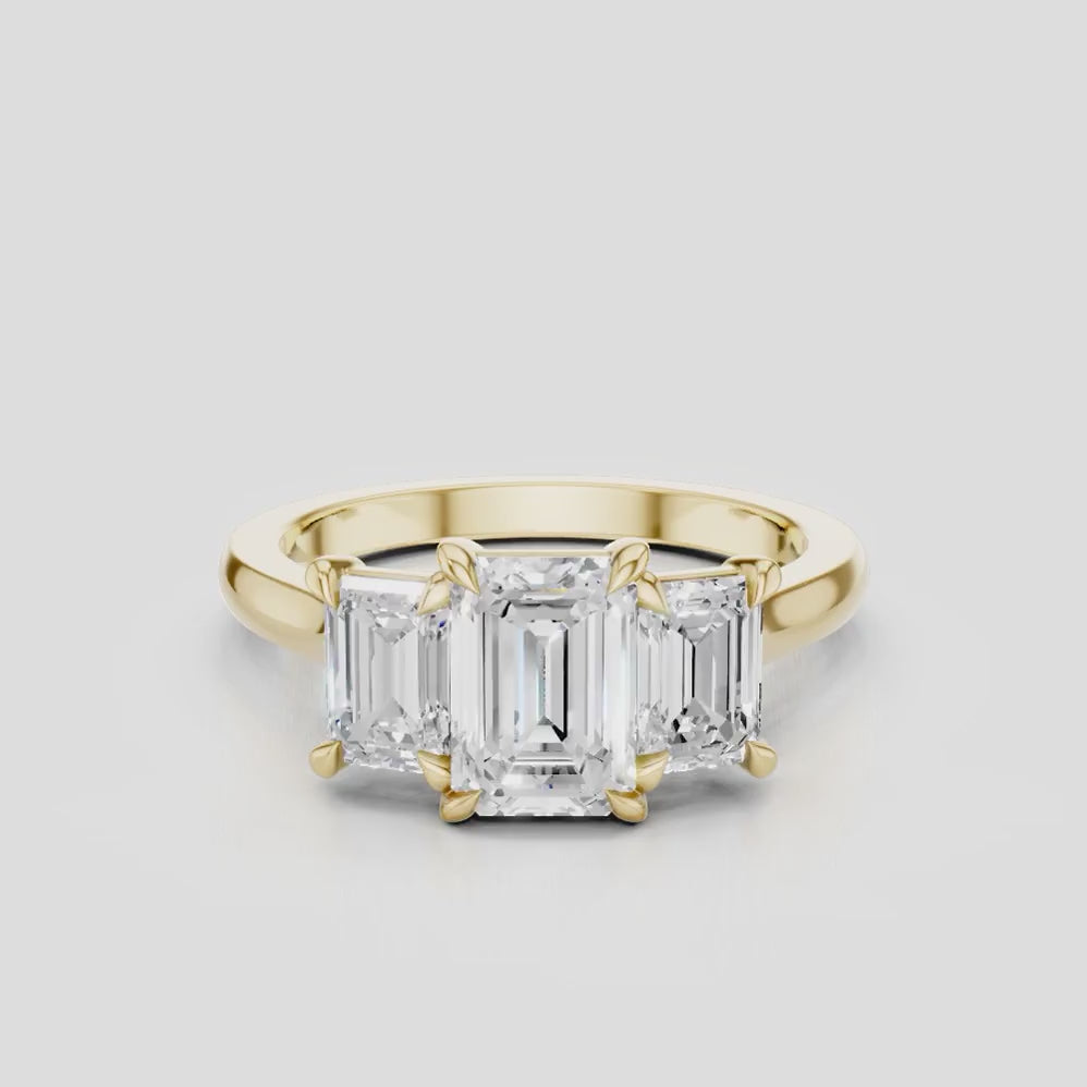 Marion emerald cut trilogy engagement ring in 18ct yellow gold