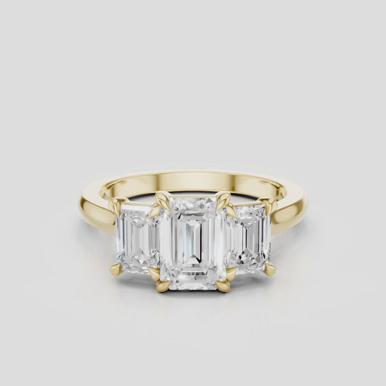 Marion emerald cut trilogy engagement ring in 18ct yellow gold